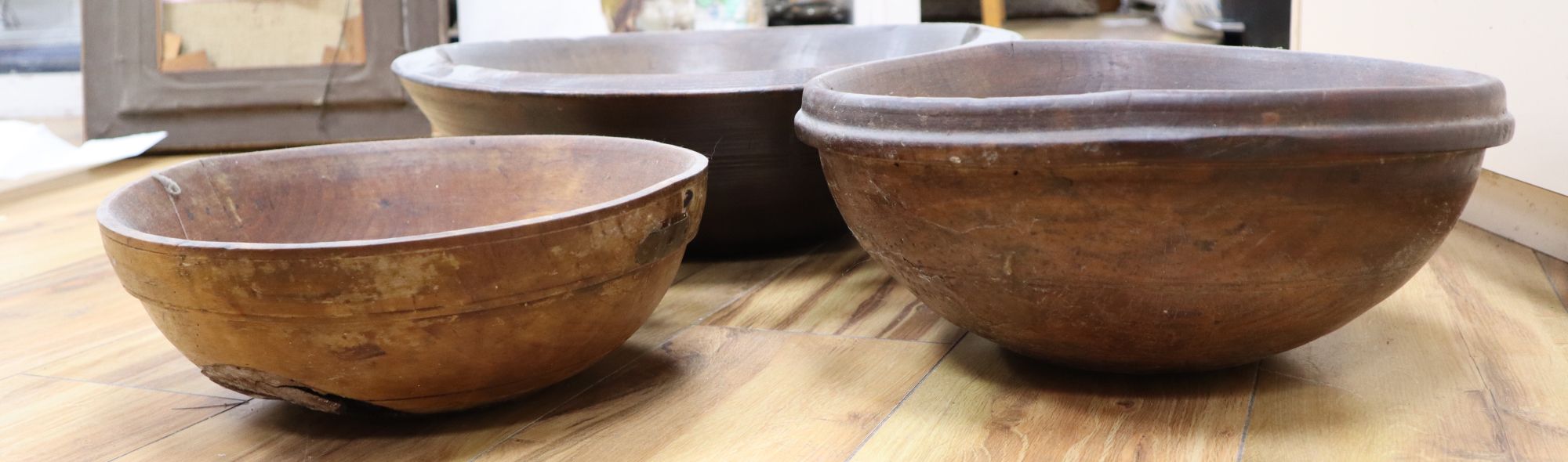 Three large treen bowls, largest diameter 47cm